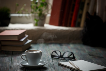 A cup of coffee in the workplace on a wooden table.