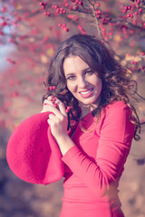 Beautiful young woman in red dress on a sunny autumn day