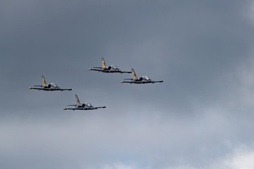 Low angle view of airshow in cloudy sky