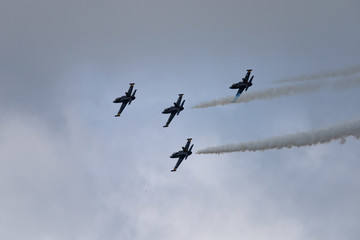 Naklejka na ściany i meble Low angle view of airshow in cloudy sky