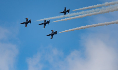 Low angle view of airshow in cloudy sky