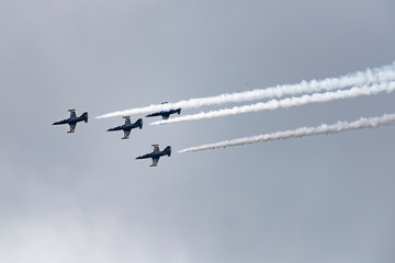 Low angle view of airshow in cloudy sky