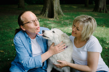 Adult couple sitting on the grass with a white hash
