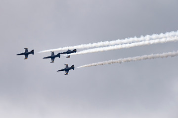 Low angle view of airshow in cloudy sky