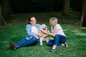Adult couple sitting on the grass with a white hash