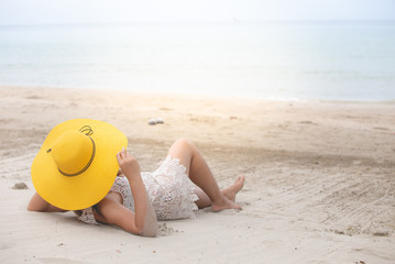 Fototapeta na wymiar Woman lying back on the beach.