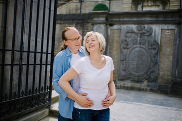 Happy middle-aged couple walking in city