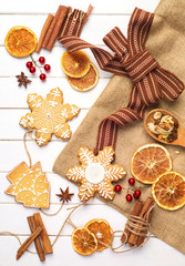 Merry Christmas - poster or postcard design. Vintage decorations, gingerbread cookies and dried orange on a light board on top.