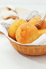 Carnival italian fritters with honey on light background.