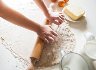 Hands Of Mother And Daughter Rolling Pizza Dough With Rolling Pin