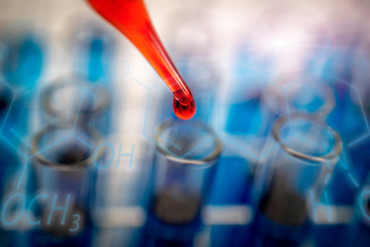 Scientist or doctor dripping chemical liquid to glassware containing test tube,science research concept.