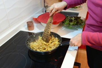 woman fries meat in a pan, close-up