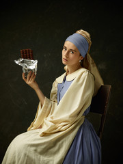Medieval woman in historical costume wearing corset dress and bonnet. Beautiful peasant girl...