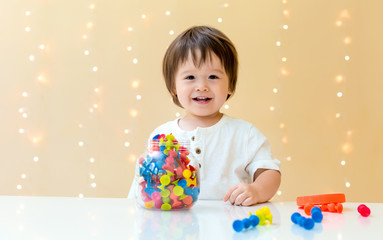 Fototapeta na wymiar Happy little toddler boy playing with his toys