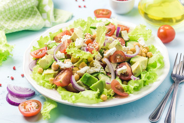 Garbanzo beans avocado cherry tomato feta cheese salad with lemon dressing. Selective focus, space for text.