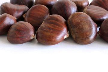 Fresh chestnuts on a white background. Isolated chestnut set. The name also refers to the edible nuts they produce. Concept of healthy and seasonal food. Autumn decorations.