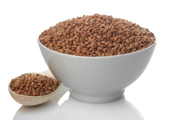 Buckwheat groats in a white bowl with a spoon on a white isolated background. porridge. healthy food. cereals.