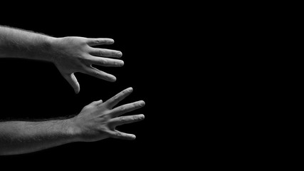 Male hands are trying to grab. Grabbing hands. Men's hands on a black background. Hands reach for the subject.