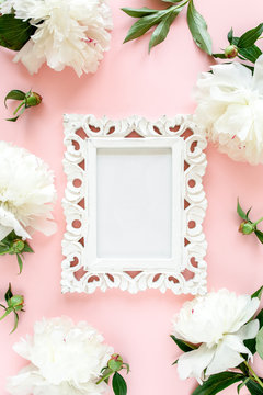 Carved, white frame decorated of white peony flowers on pink background. Peony texture. Flat lay, top view. 