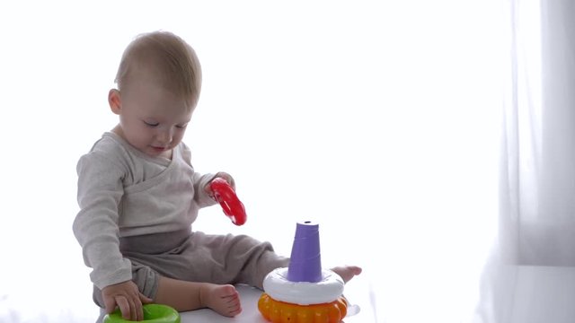 cute toddler played educational toys pyramid in bright room close-up