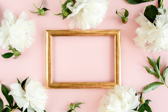 Gold frame decorated of white peony flowers on pink background. Peony texture. Flat lay, top view. 