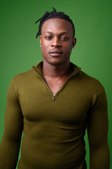 Young handsome African man from Kenya against green background