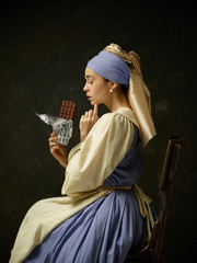 Medieval woman in historical costume wearing corset dress and bonnet. Beautiful peasant girl...