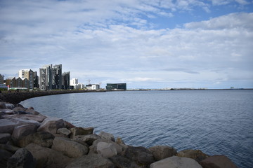 Cityscape of Reykjavik, capital city of Iceland. Modern buildings and sea under cloudy sky. Reykjavik, Iceland, September, 2018