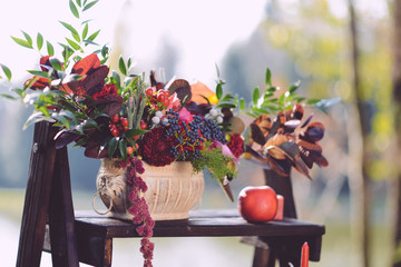 set of autumn wedding decor outdoors. Floral arrangement of flowers and fruits. details of the...