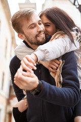 Portrait of a young romantic couple hugging during the city walk at the warm autumn day. Two lovers are walking and hugging in Lviv, Ukraine