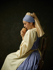 Medieval Woman in Historical Costume Wearing Corset Dress and Bonnet with burger. Beautiful peasant...