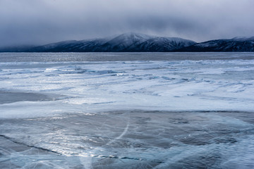 Lake Khubsugul is covered with ice and snow, strong cold, thick clear blue ice. Lake Khubsugul is a frosty winter day. Amazing place