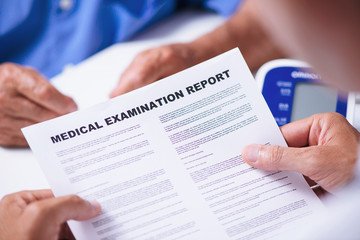 doctor reading a medical report of a senior man