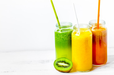 Fresh detox juices in glass bottles on white background