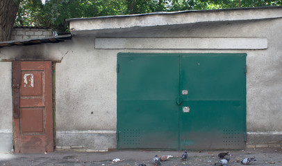 Metal gates and wooden door to the warehouse, garage