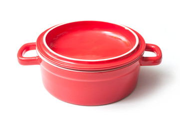 closeup of red ceramic saucepan on white background