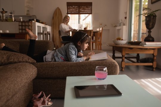 Girl reading a book in living room