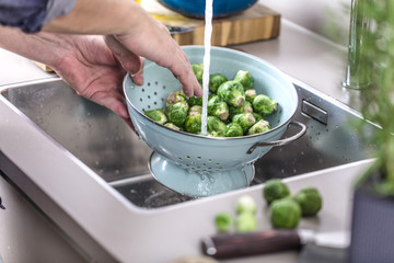 washing raw Brussels sprouts in kitchen sink