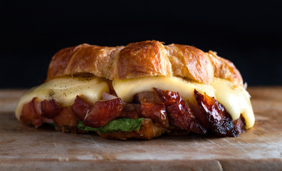 Delicious croissant with melted cheese and pulled pork meat