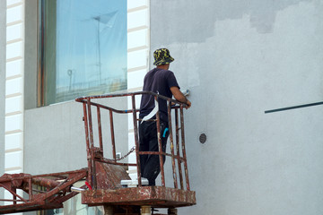 people at work house painter paints the facade of the house