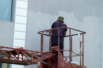 people at work house painter paints the facade of the house