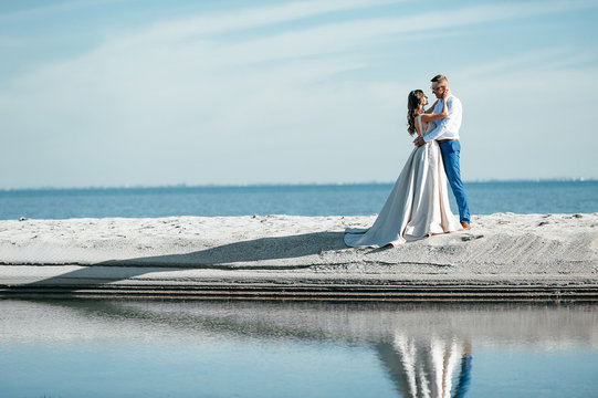 bride and groom on the beach near the fabulous island after the marriage ceremony