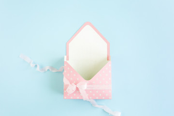 Envelope for flowers on blue background. Minimal floral concept greeting card. Flat lay, top view. 