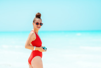 happy young woman with retro photo camera on beach