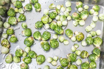 washing raw Brussels sprouts in kitchen sink
