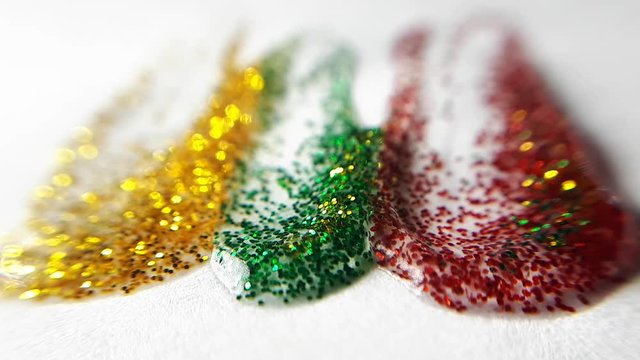 Yellow, Green and Red Glittering Smudges On a White Paper. Macro Close Up Shot.