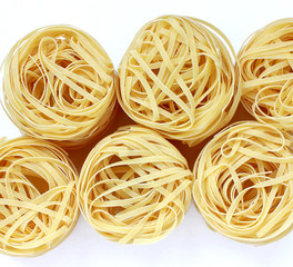  nests of pasta on white background