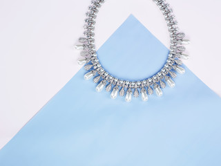 Beautiful necklace on blue paper background
