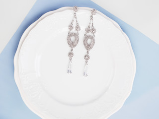 jewelry on plate. Beautiful earrings, background