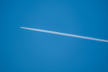 Trail from an airplane in the blue sky